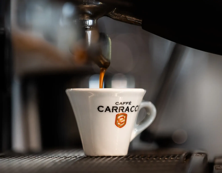 Macchina del caffè eroga l'espresso in una tazzina Carracci