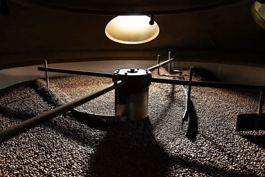 Tostatura dei chicchi di caffè in una tostatrice a tamburo