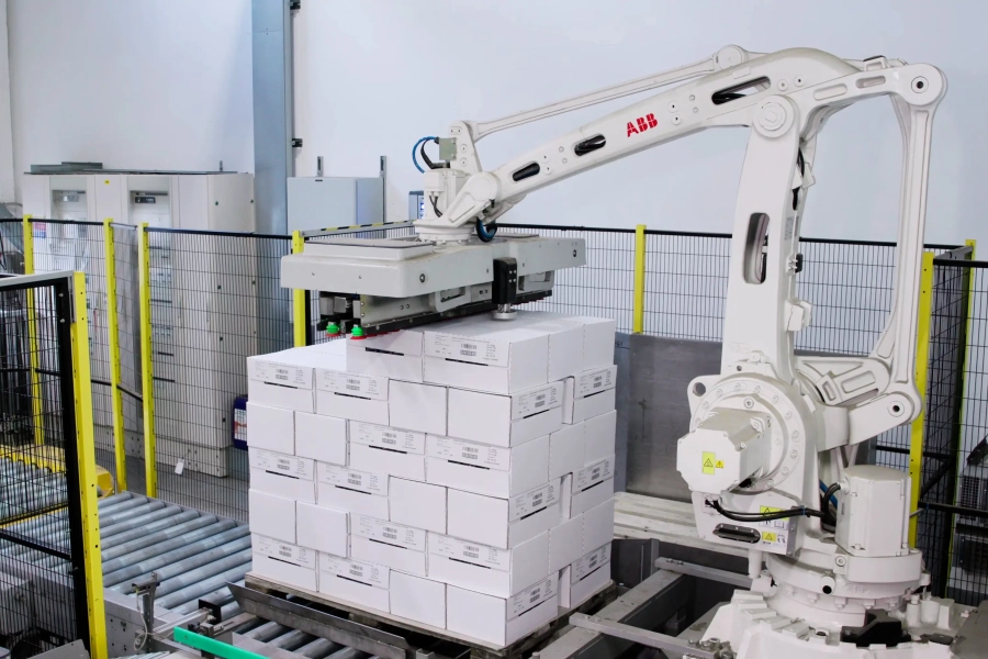 Braccio robotico automatizzato organizza scatole di caffè prima di essere depositate nei magazzini