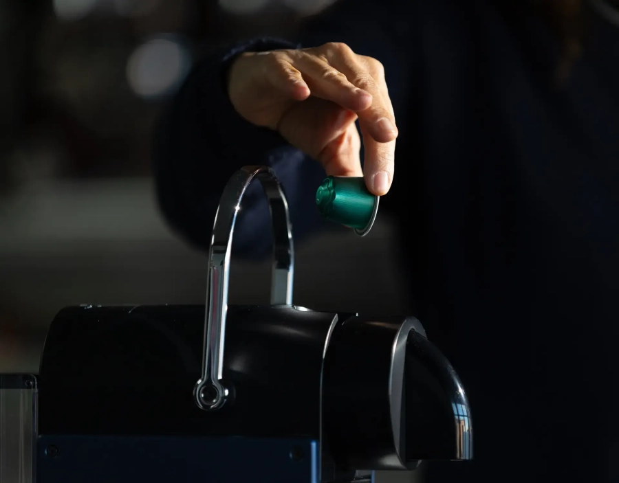 Capsula in alluminio viene inserita in una macchina del caffè Nespresso